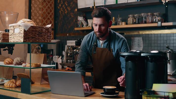 Barista bekerja di balik counter cafe